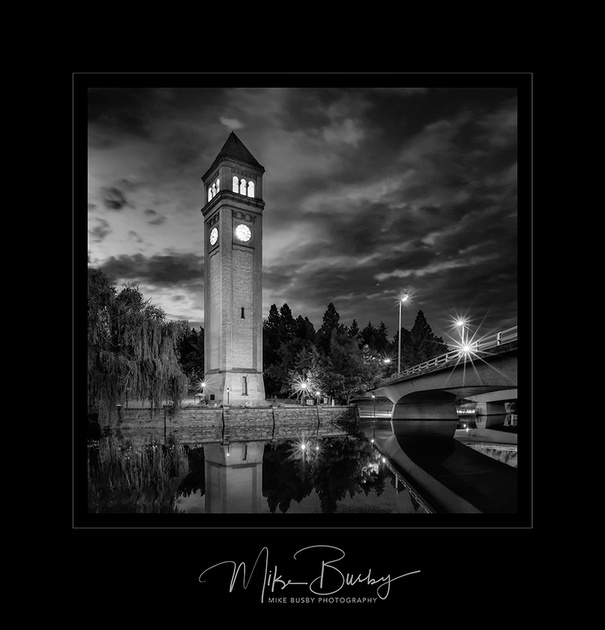 A photograph of the Spokane Clock Tower taken at night. It is presented in black and white.